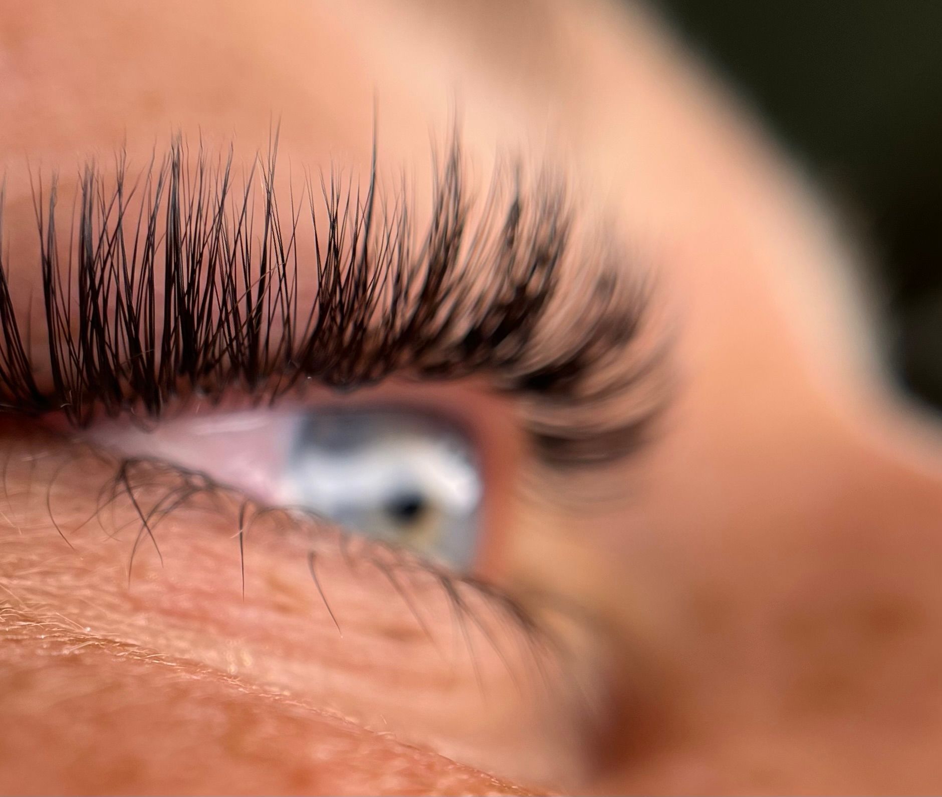 A close up of a woman 's eye with long eyelashes.