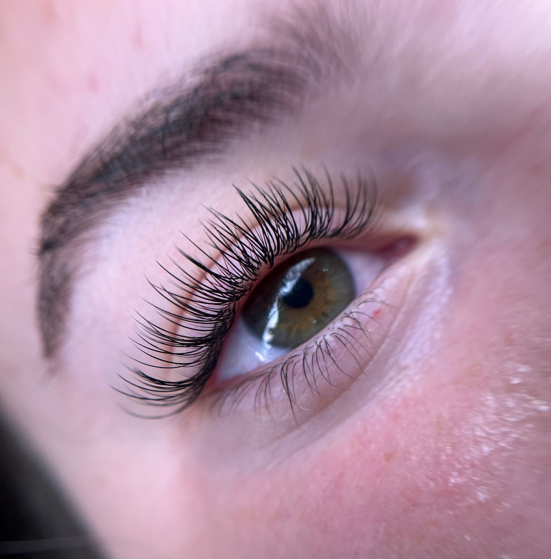 A close up of a woman 's eye with long eyelashes.