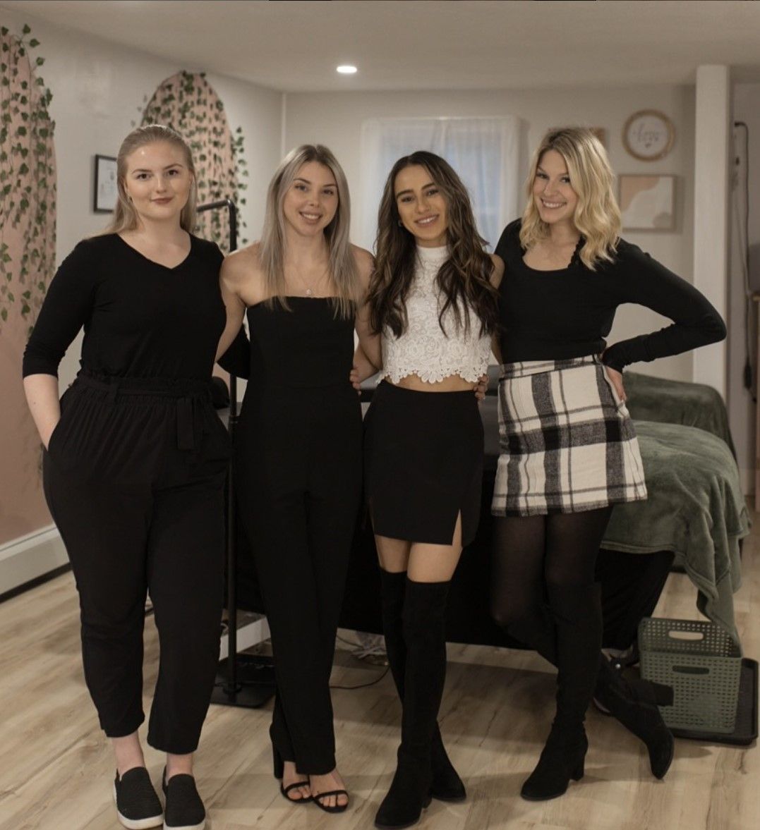 Four women are posing for a picture in a living room
