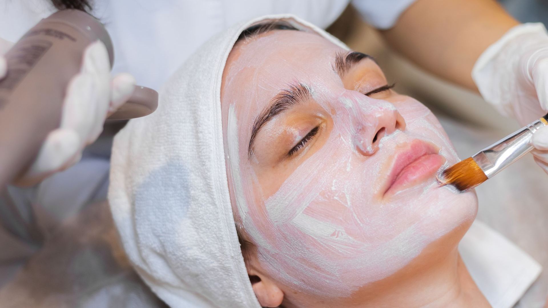 A woman is getting a facial treatment at a spa.