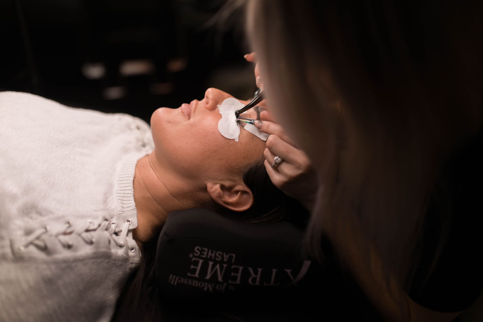 A woman is getting her eyelashes done at a beauty salon.