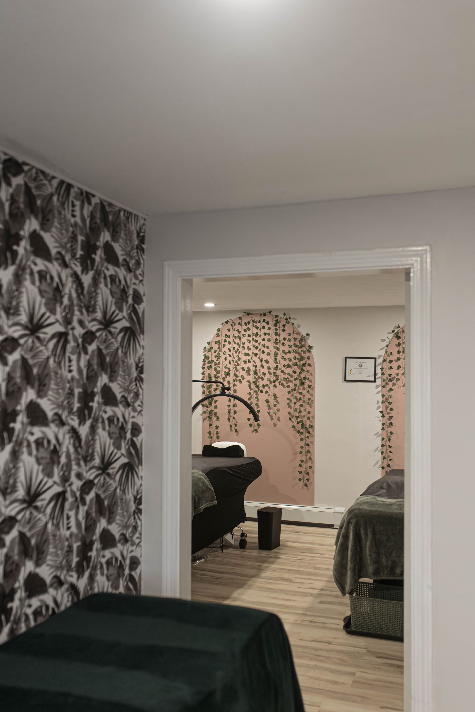 A room with two beds and a doorway leading to another room.