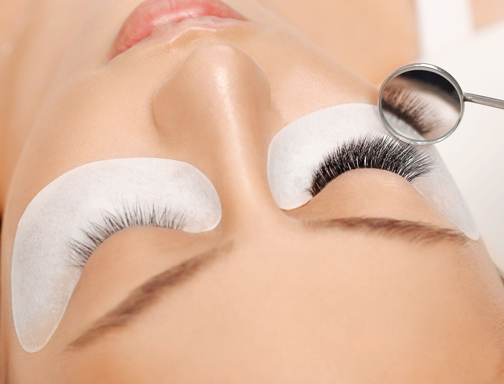 A woman is getting her eyelashes done at a beauty salon.