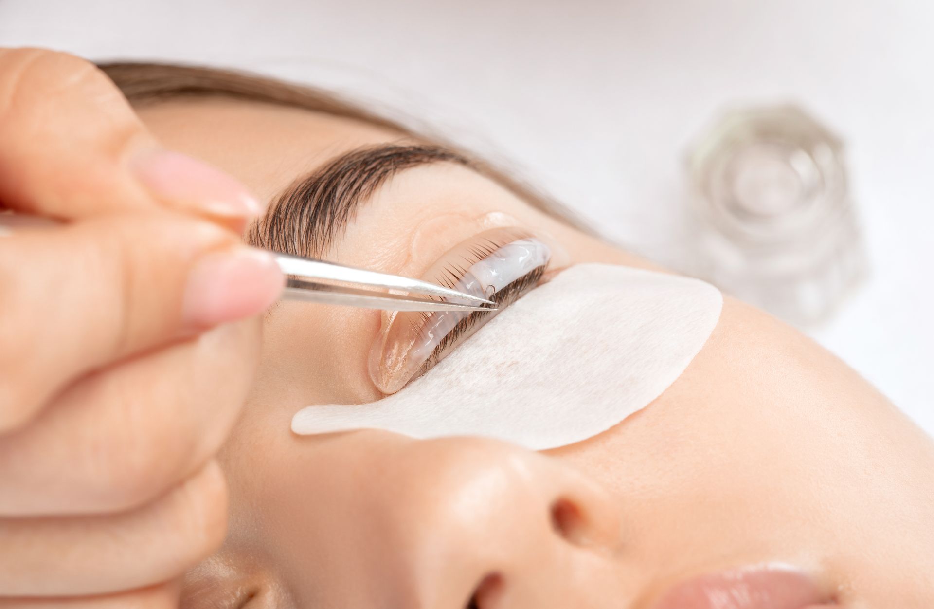 A woman is getting her eyelashes done at a beauty salon.