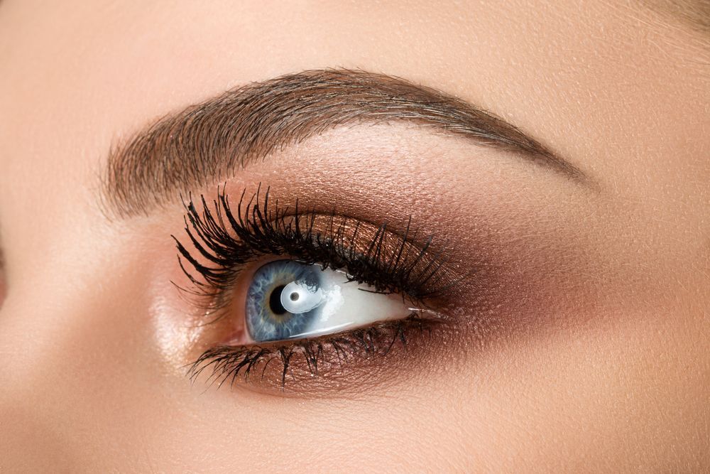 A close up of a woman 's blue eye with makeup.