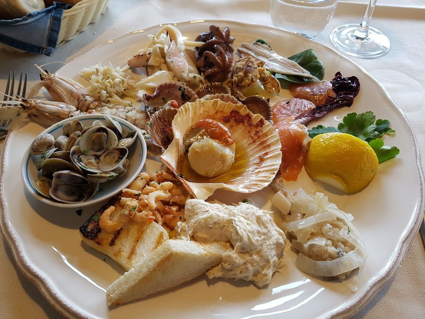 A white plate topped with a variety of seafood and vegetables