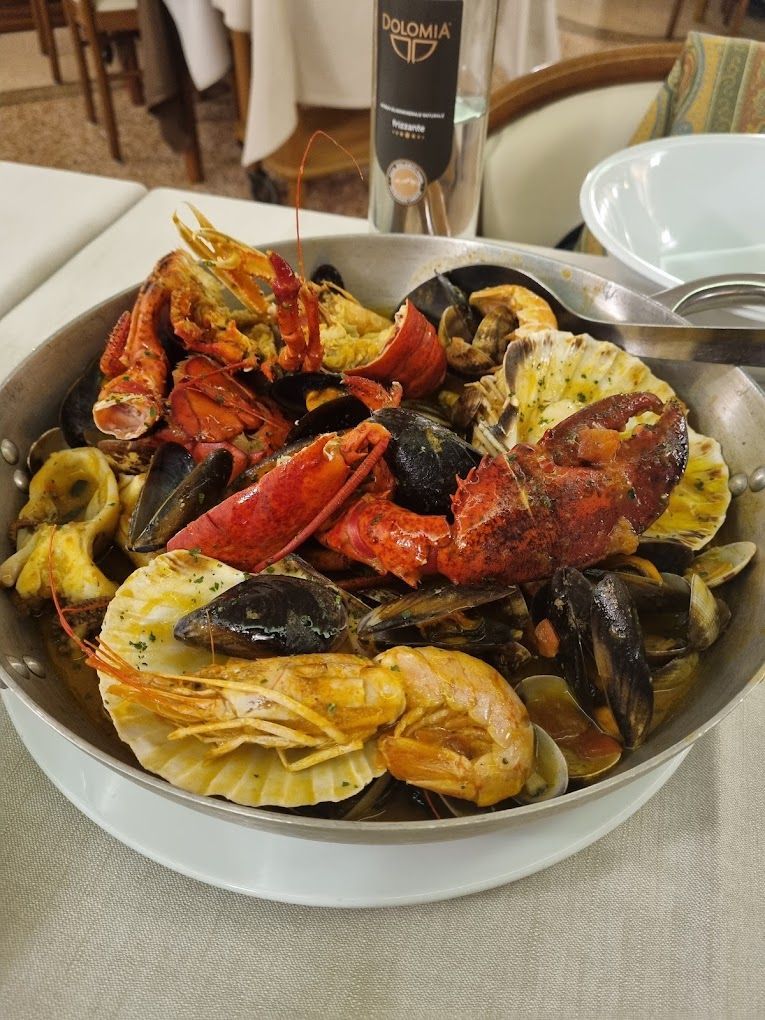A pan filled with lobsters , shrimp , mussels and scallops on a table.