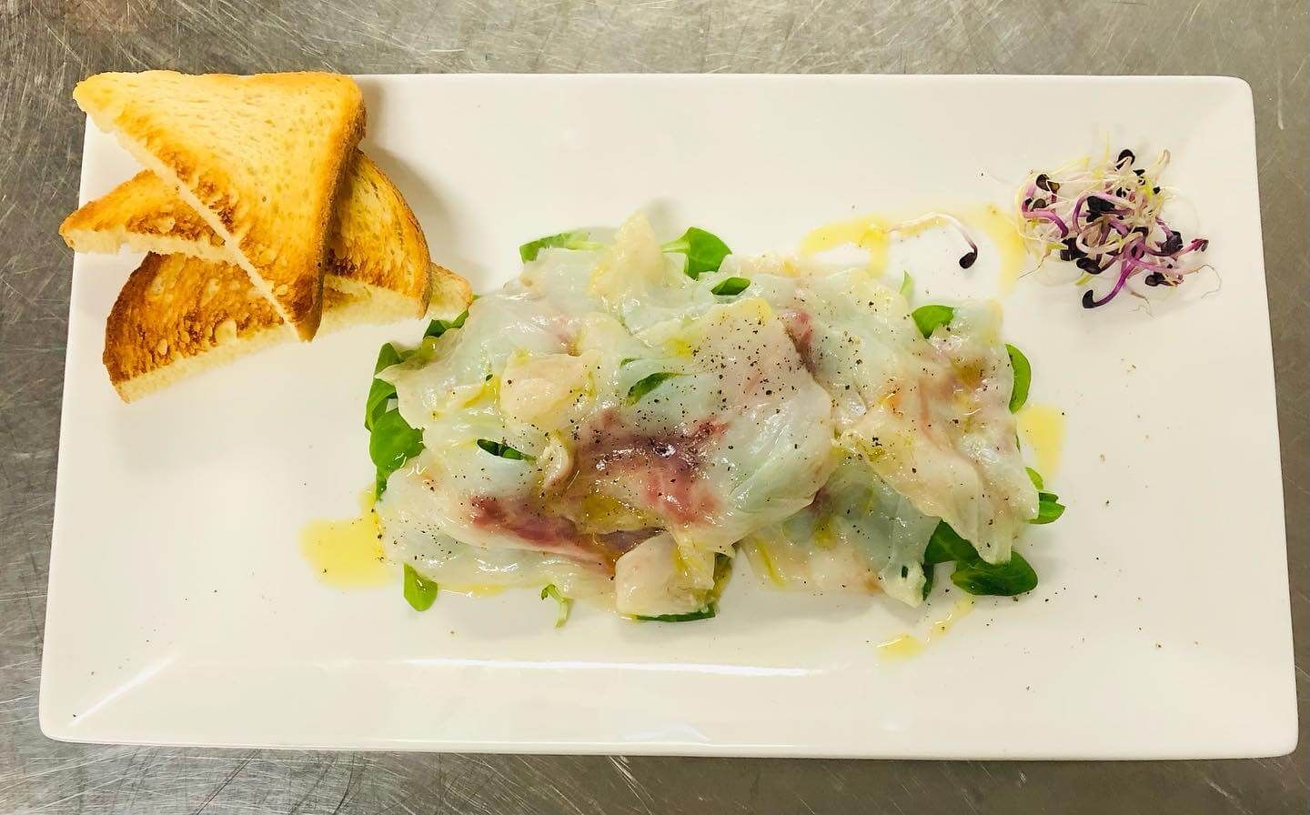 A white plate topped with food and toast on a table
