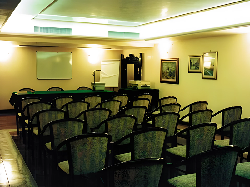 A conference room with rows of chairs and a table