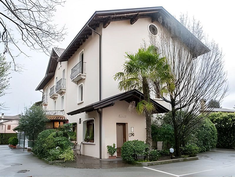 A large white house with a palm tree in front of it