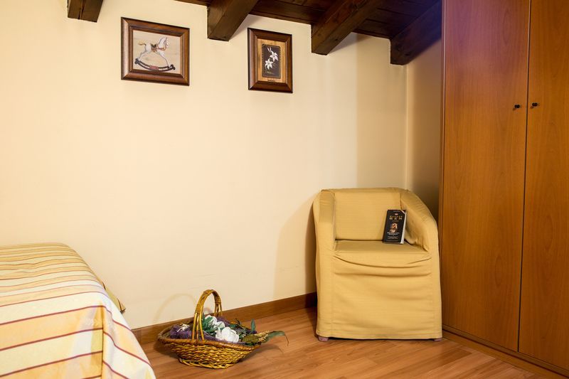 There is a chair and a basket in the corner of the room.