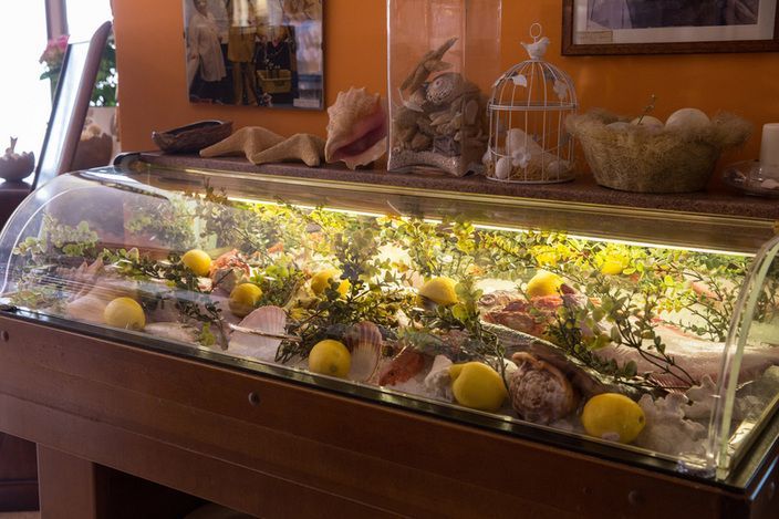 Una teca di vetro piena di limoni e conchiglie.