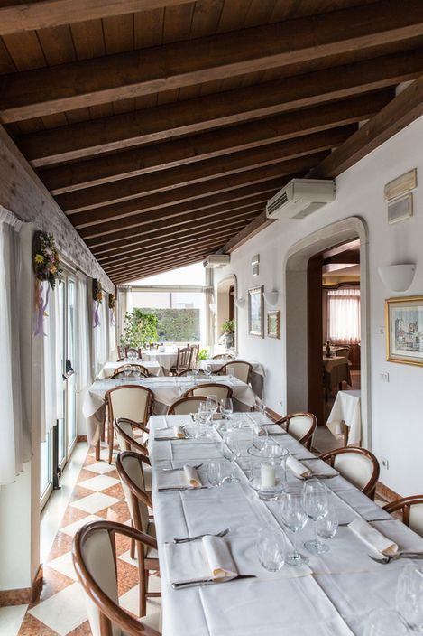A long table in a restaurant with a white table cloth