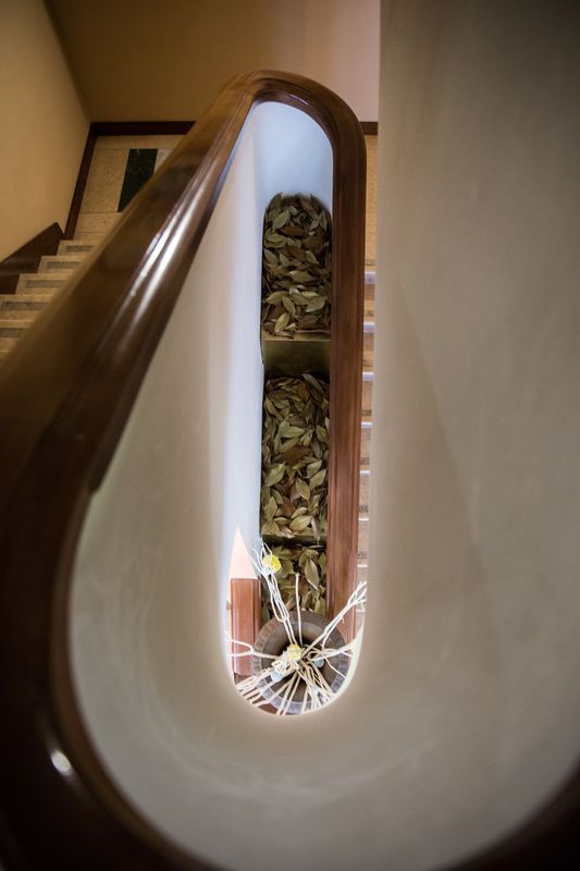 Una scala con una ringhiera di legno e una finestra di vetro rotta.