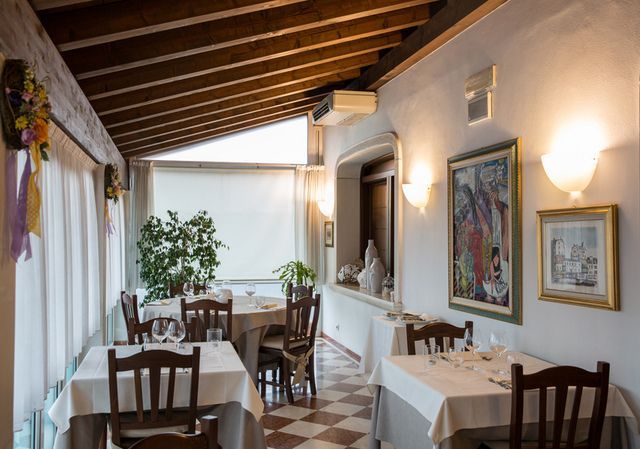 Un ristorante con tavoli e sedie e un dipinto sul muro