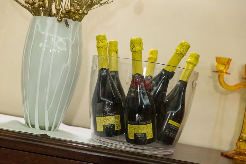 Un secchio di bottiglie di champagne è appoggiato su un tavolo accanto a un vaso.