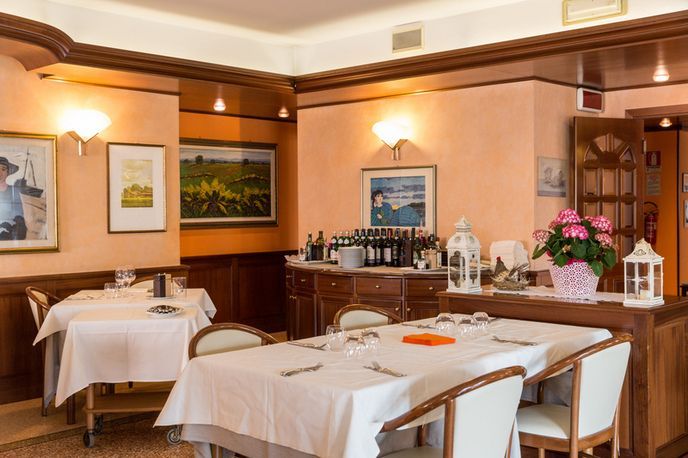A dining room with tables and chairs and a bar.