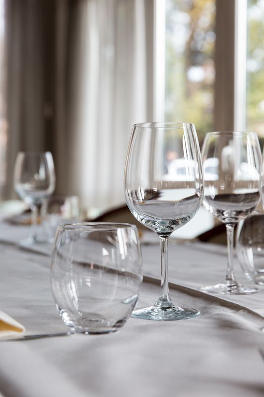 Un tavolo con sopra bicchieri da vino e bicchieri d'acqua.