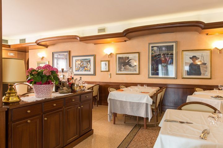 A restaurant with tables and chairs and pictures on the wall