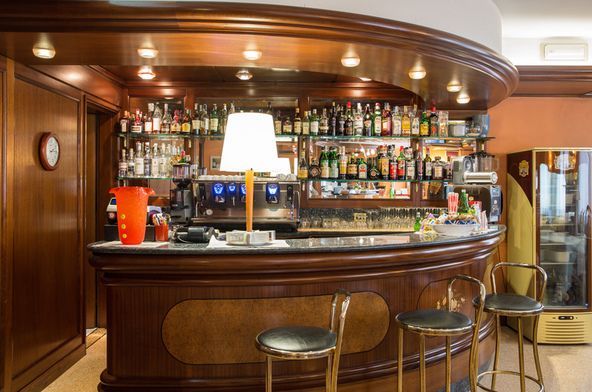 Un bar con un sacco di bottiglie di alcolici sugli scaffali.