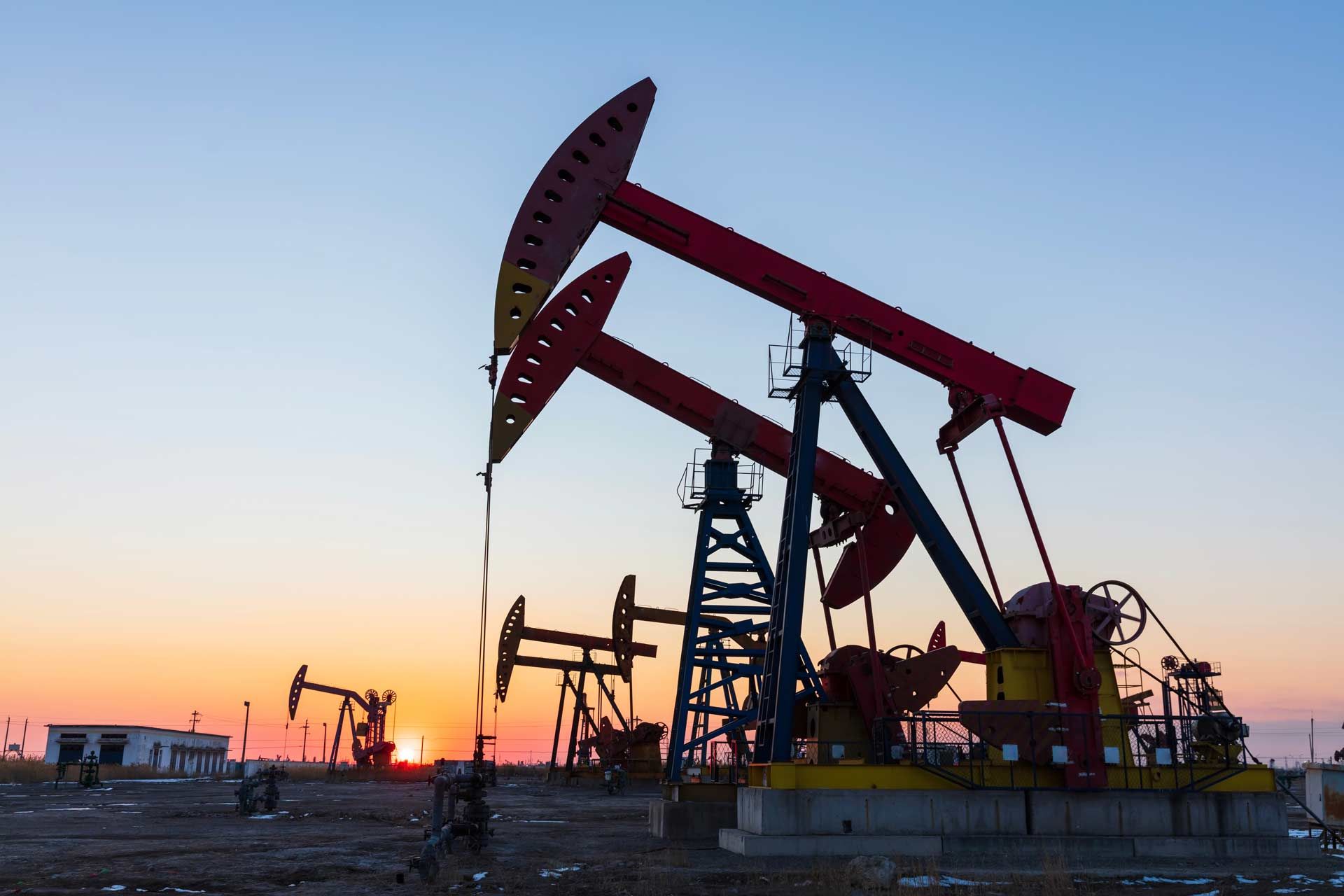 Oil pumps in silhouette at sunset.