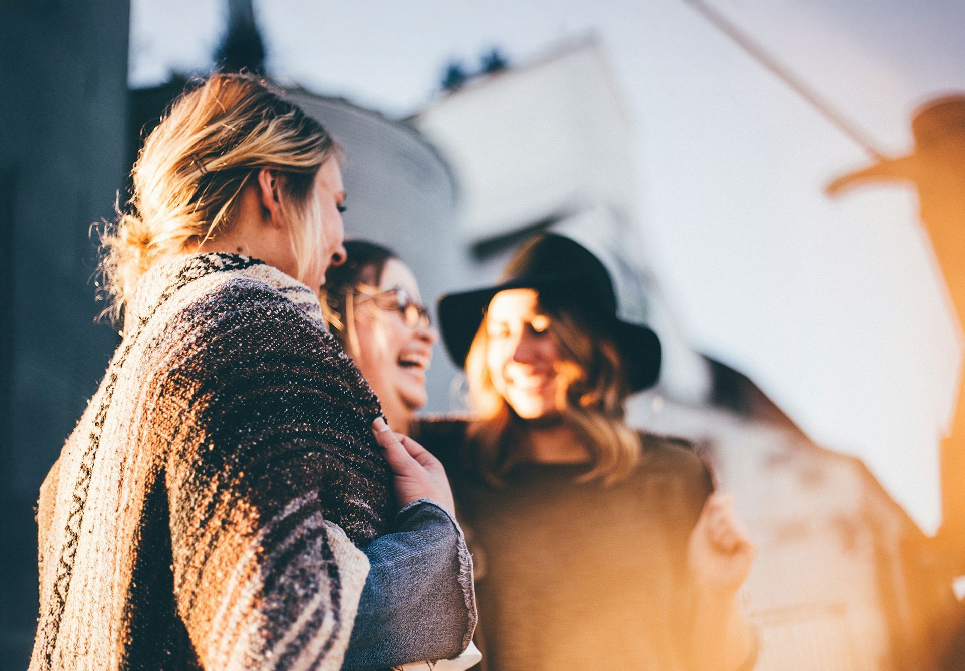 A woman with blonde hair is standing in front of a white wall.