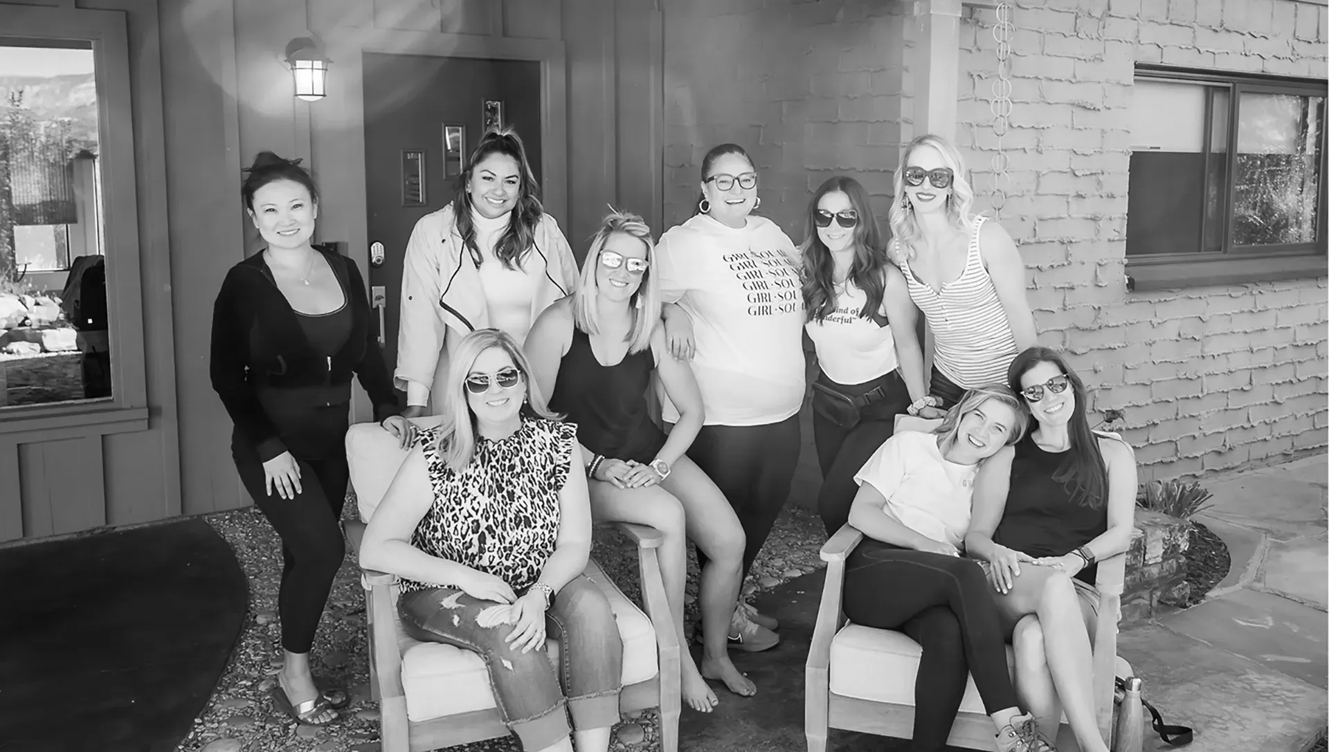 Two women are sitting at a table talking to each other in a black and white photo.