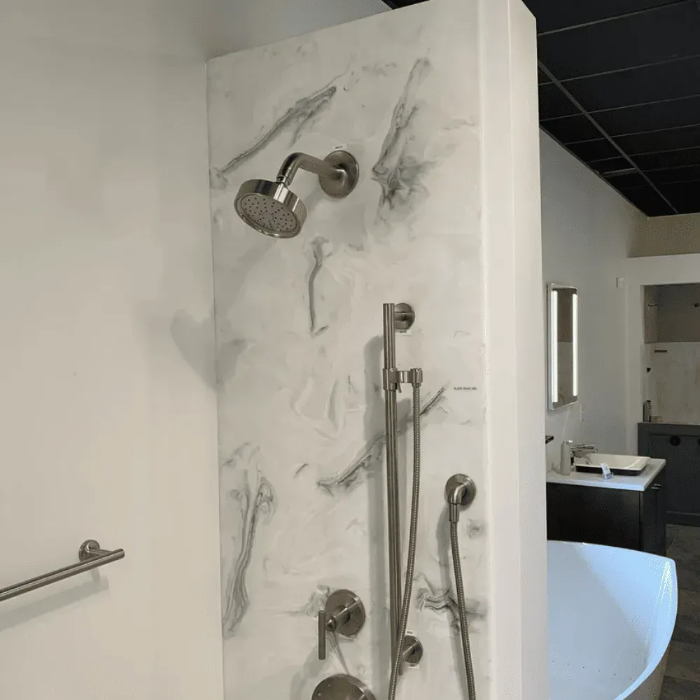 Shower display with silver fixtures against a white and gray patterned wall by Syn-Mar