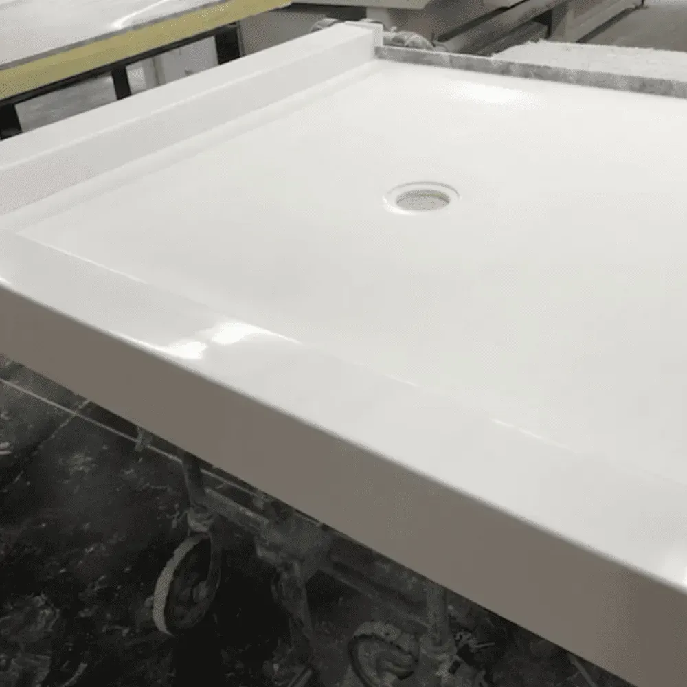 White shower base with drain, on a metal frame, in a workshop by Syn-Mar