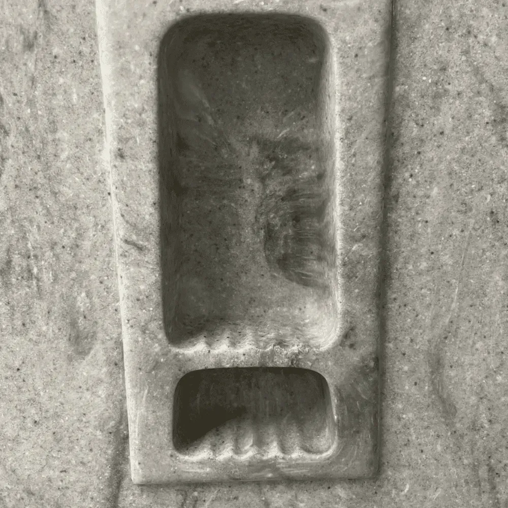 Footprints carved into stone, rectangular structure by Syn-Mar