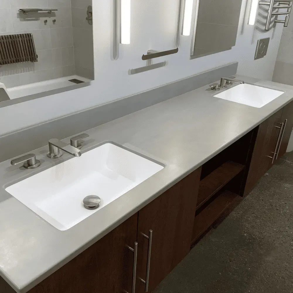 Bathroom with a double sink vanity made of dark wood and a concrete countertop by Syn-Mar