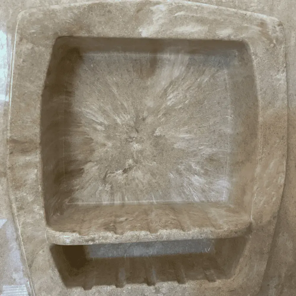 Built-in beige shower soap dish with a bottom shelf and a splash-like design in the center by Syn-Mar