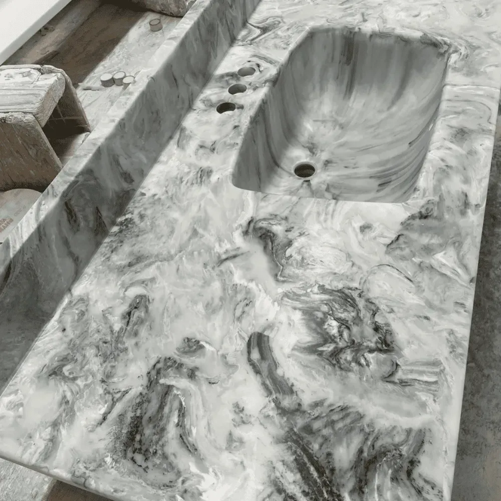Marble-patterned bathroom countertop with built-in sink and faucet holes; neutral colors by Syn-Mar