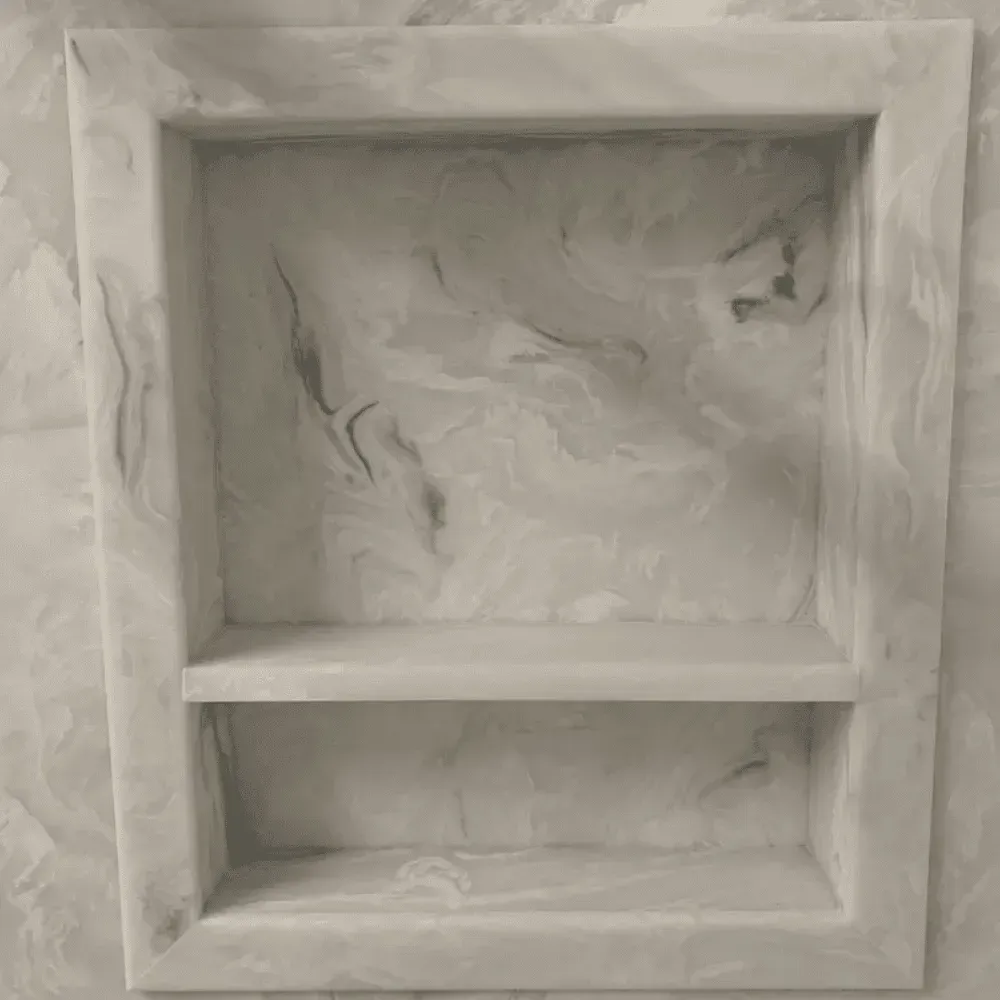 Recessed shower shelf with marble-like gray and white swirls. Single shelf divides the space by Syn-Mar