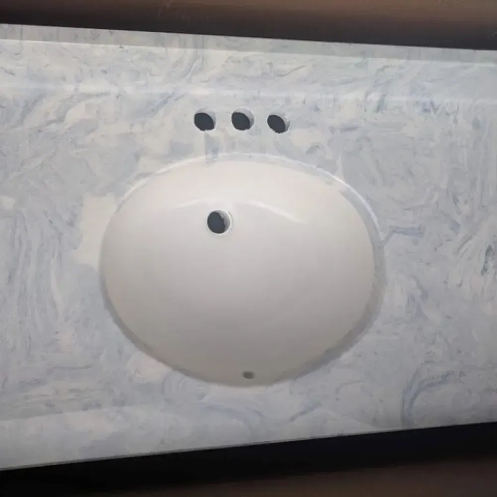 White oval sink in a blue and white patterned countertop by Syn-Mar