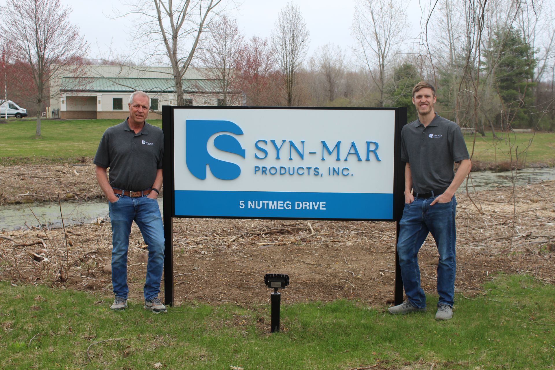 Tim Hill (Left) and Derek Hill (Right) standing at new Syn-Mar sign 