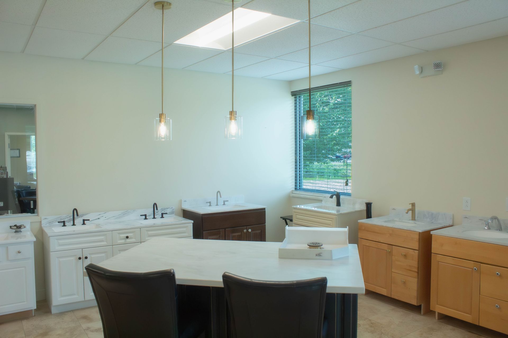 Bright kitchen with white island, black chairs, wooden cabinets, and a window with greenery outside