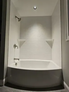 Bathroom vanity with light-up mirror, blue vase, wooden cabinets, and a window with a view by Syn-Mar