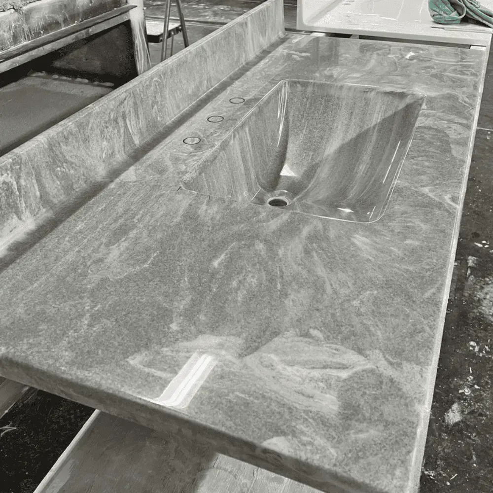 Gray granite countertop with integrated sink and faucet holes by Syn-Mar
