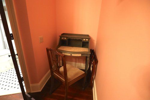 A small desk and chair in a corner of a room