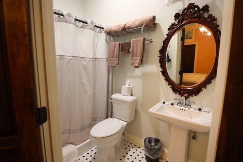 A bathroom with a toilet , sink and mirror.