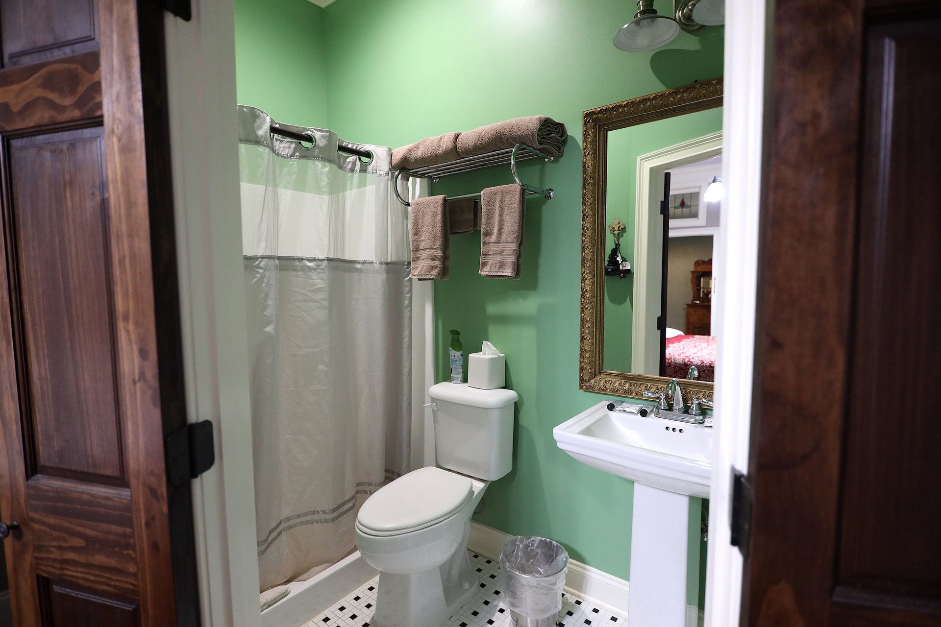 A bathroom with a toilet , sink , shower and mirror.