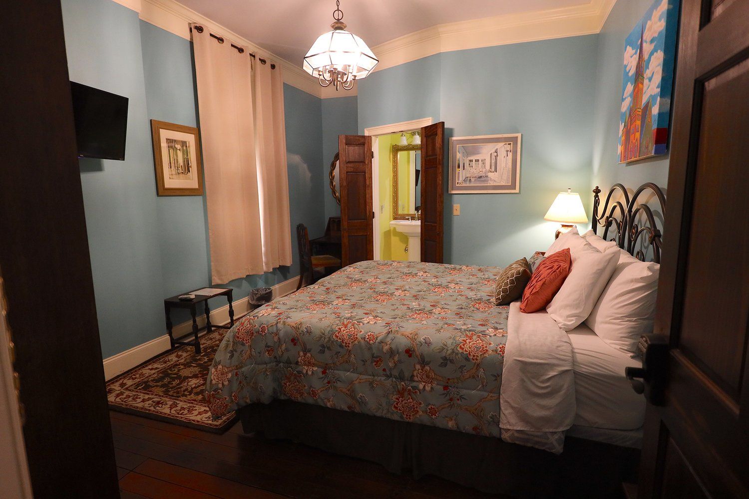 A bedroom with a king size bed and a television.