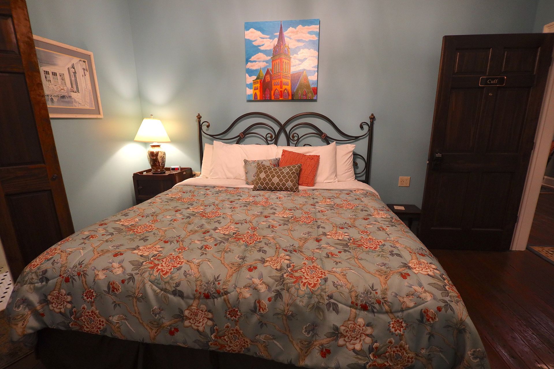 There is a painting on the wall above the bed in the bedroom.