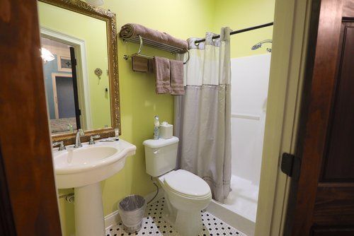 A bathroom with a toilet , sink and shower.