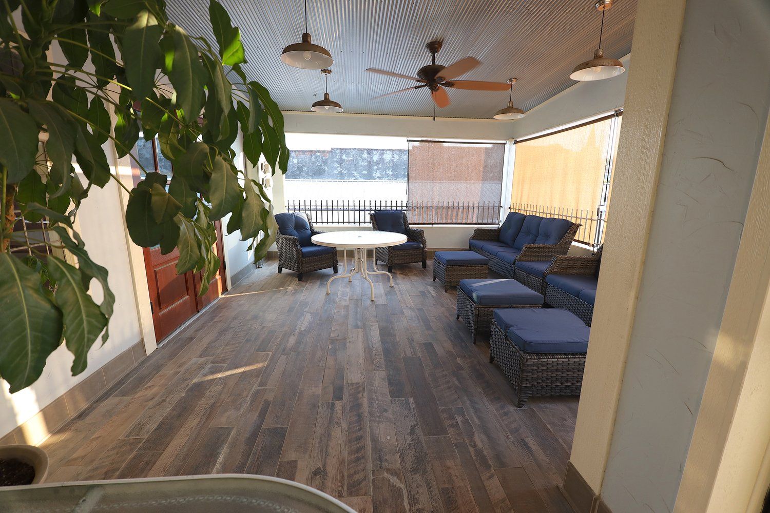 A large patio with a lot of furniture and a ceiling fan.