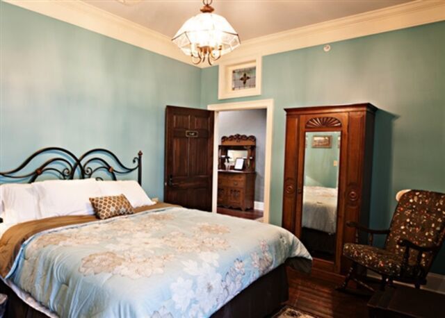 A bedroom with a king size bed and a chair