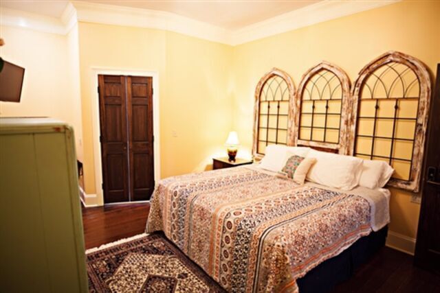 A bedroom with a king size bed and a rug