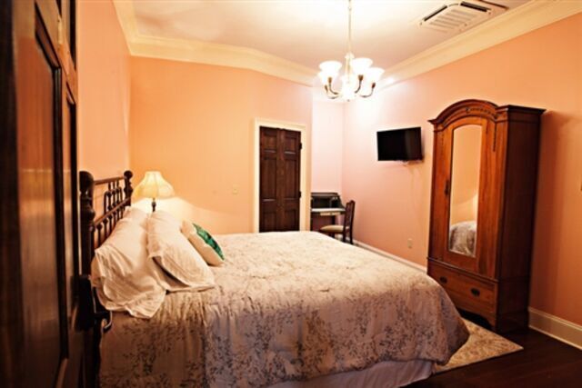 A bedroom with a king size bed and a wardrobe