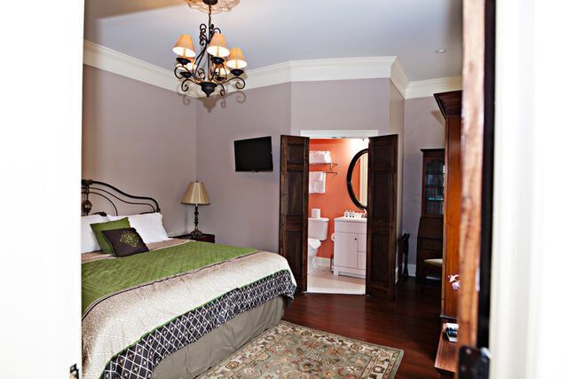 A bedroom with a king size bed and a chandelier.